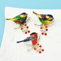 Een vogel zittend op een tak - kristallen brocheBroches