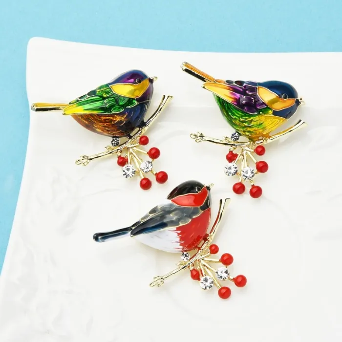 Een vogel zittend op een tak - kristallen brocheBroches