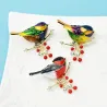 Een vogel zittend op een tak - kristallen brocheBroches