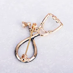 Broche in de vorm van een stethoscoop met kristalBroches