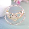Elegante ronde broche - met kristallen - hartvormige handen ineenBroches